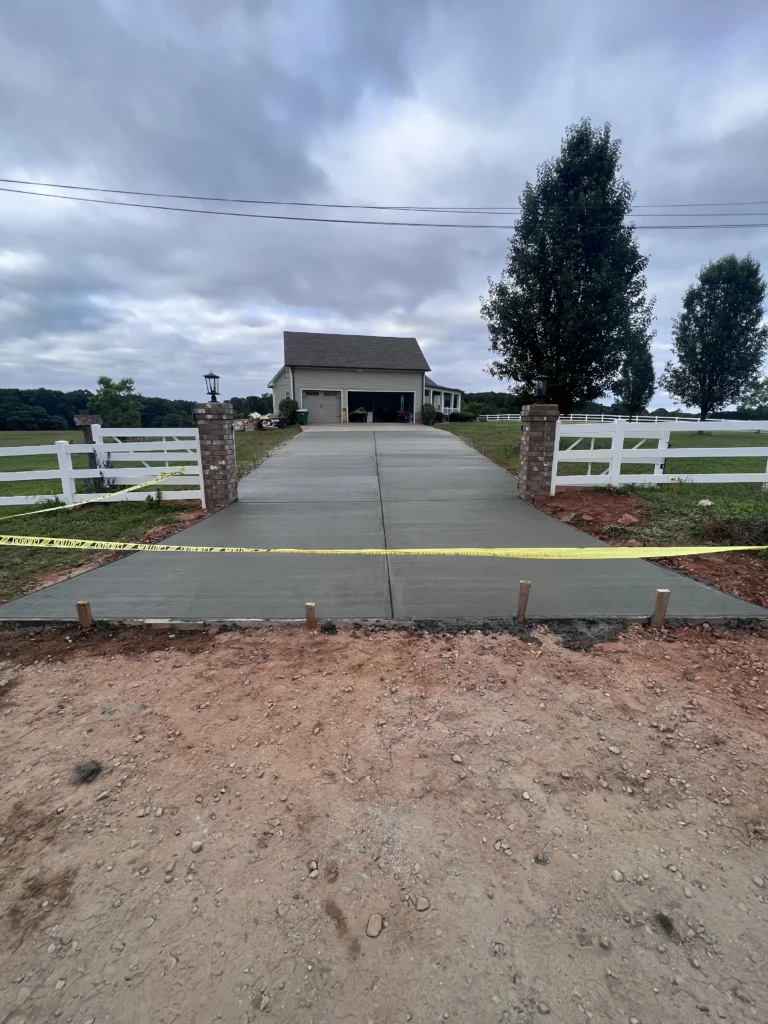 New concrete driveway installation with brick entryway pillars in Metro Atlanta