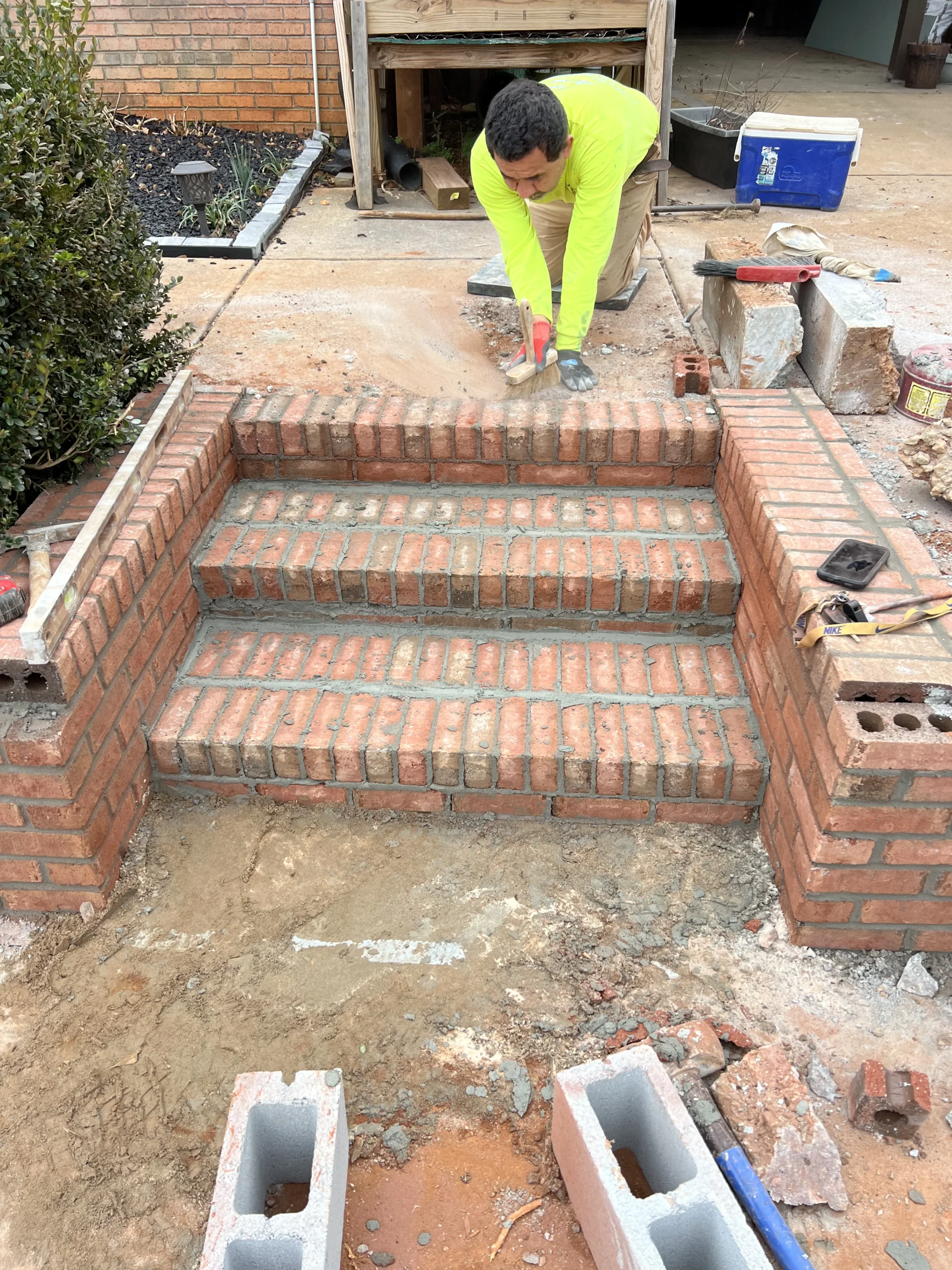 Masonry contractor repairing damaged residential brick steps