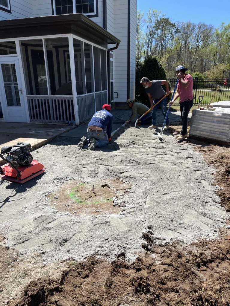 Masonry crew preparing base ground for residential patio installation in Metro Atlanta