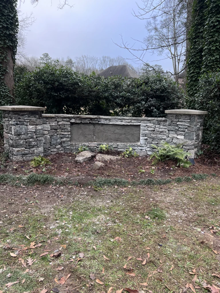 Stacked stone retaining wall and decorative entrance monument built for residential property in Atlanta